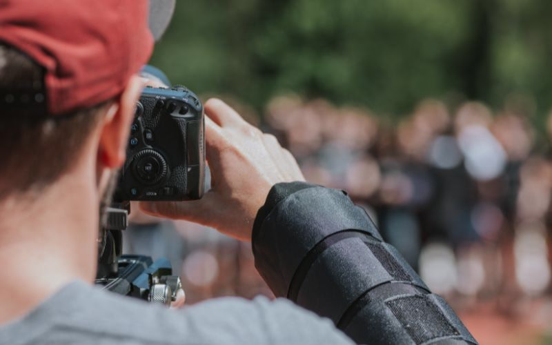Beginner following an online photography lesson while practicing with a DSLR camera.